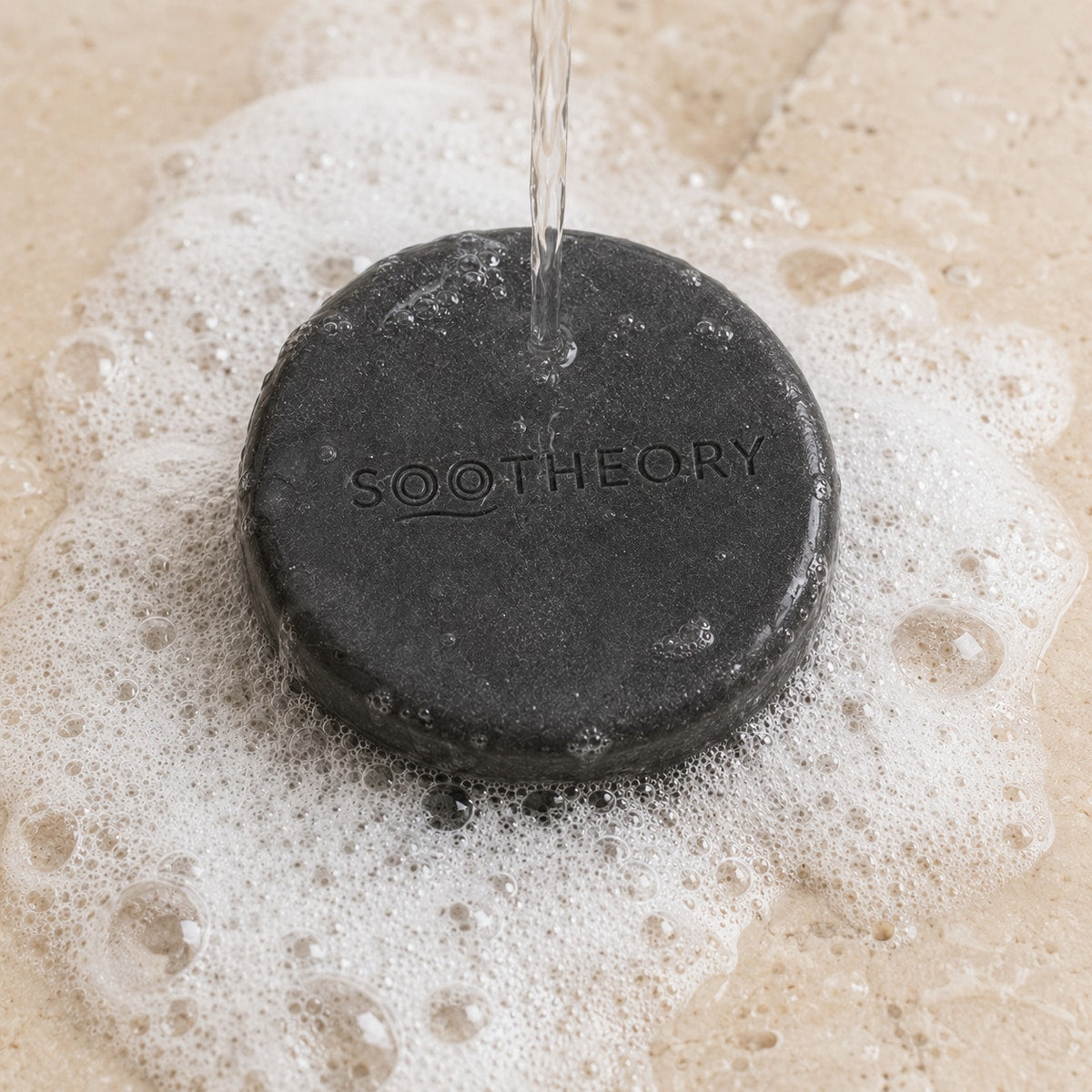 Charcoal dog shampoo bar under water with clean white lather