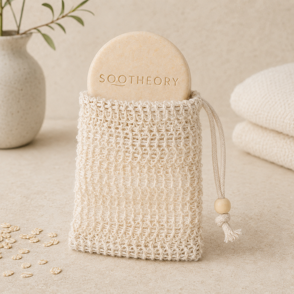 Ivory lathering mesh pouch holding a round SOOTHEORY dog shampoo bar